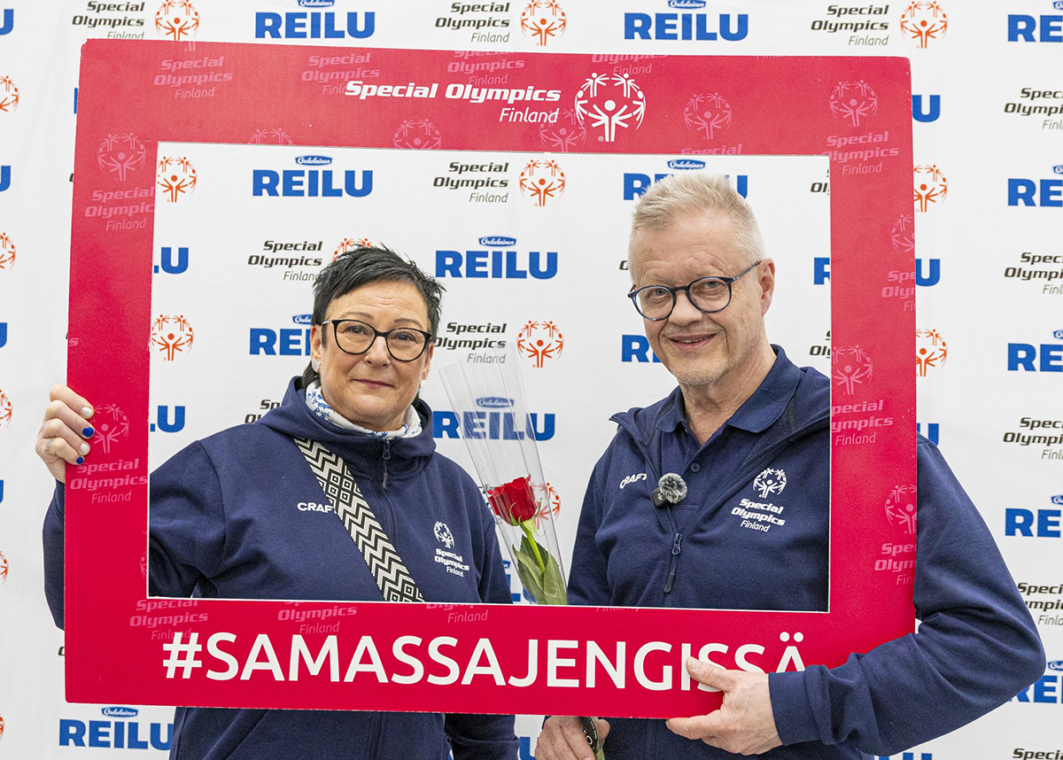 Helvi Hellsten ja Matti Putila punaisen Samassa Jengissä -kehyksen sisällä poseeraamassa kameralle.